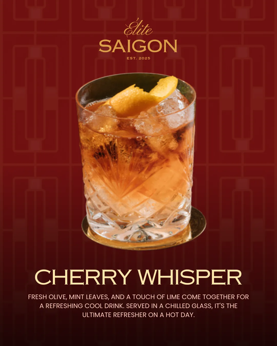 A cut-crystal rocks glass of amber sparkling drink with a large orange twist, on a brass coaster against deep red