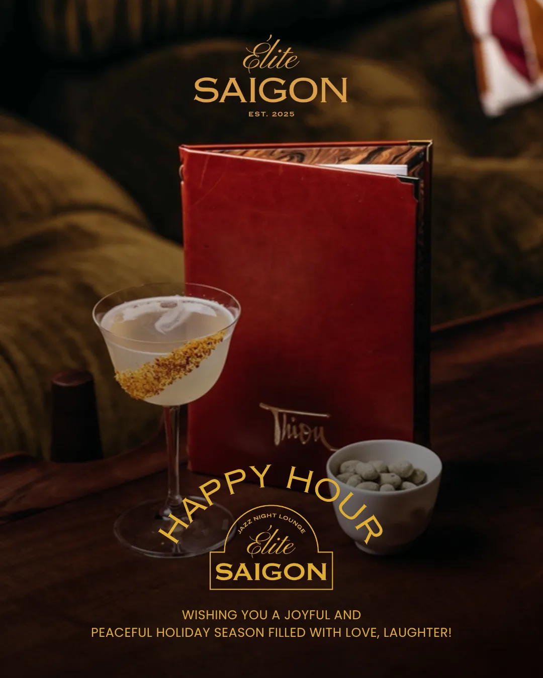 A gold-rimmed coupe beside a red leather menu and a bowl of wasabi nuts on dark wood, olive velvet seating behind