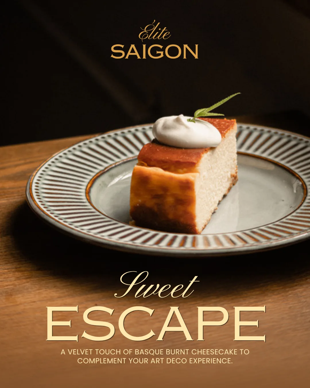 A slice of Basque burnt cheesecake with a quenelle of cream and a rosemary sprig, on a fluted grey-rimmed plate